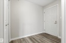 Entryway featuring wood-finish flooring, light gray wall paint, and white baseboards - 407 13635 34 Street Nw, Edmonton, AB  - Indoor Photo Showing Other Room 