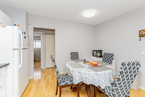 Dining area featuring wood-finish flooring, light gray walls, and a ceiling-mounted light fixture - 10412 39 Avenue, Edmonton, AB - Indoor Photo Showing Dining Room