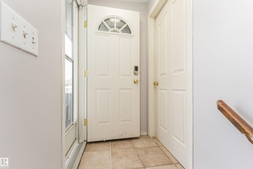 Entryway featuring a panel door with an arched transom window, a storm door, and tile flooring - 10412 39 Avenue, Edmonton, AB - Indoor Photo Showing Other Room