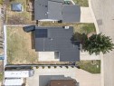 Property featuring a dark shingle roof with solar panels, an elongated driveway, and a spacious rear yard - 10412 39 Avenue, Edmonton, AB  -  