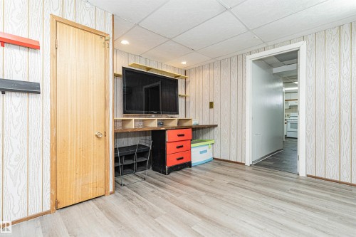 Room featuring wood-finish flooring, wood-paneled walls, and a drop ceiling - 10412 39 Avenue, Edmonton, AB - Indoor Photo Showing Other Room