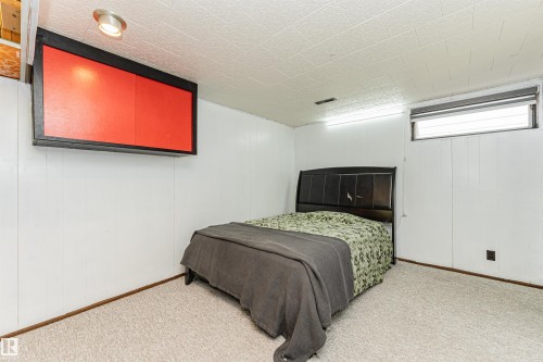 Room featuring white panel walls, textured ceiling, and light-colored carpet flooring - 10412 39 Avenue, Edmonton, AB - Indoor Photo Showing Bedroom