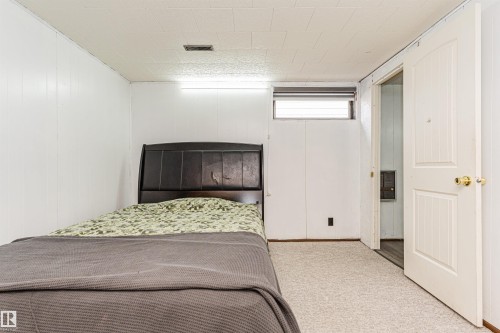 Carpeted room featuring white paneled walls and a white textured ceiling - 10412 39 Avenue, Edmonton, AB - Indoor Photo Showing Bedroom