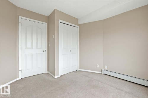 Neutral-toned walls complement the light beige carpeting - 303 11804 22 Avenue, Edmonton, AB - Indoor Photo Showing Other Room