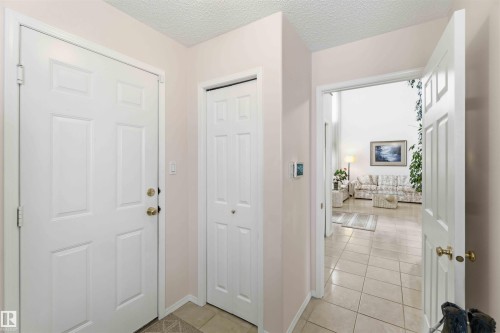The property features a tiled entryway with a white paneled door and a bi-fold closet - #1 Colonial Close, Beaumont, AB - Indoor Photo Showing Other Room