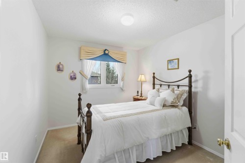 Bright room featuring a window with a valance, light-colored walls, and carpeted flooring - #1 Colonial Close, Beaumont, AB - Indoor Photo Showing Bedroom