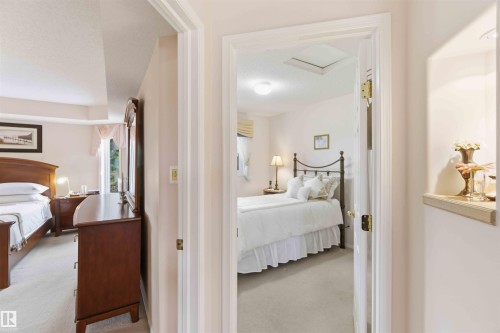 The property features bright rooms with light-colored walls and soft carpeting throughout - #1 Colonial Close, Beaumont, AB - Indoor Photo Showing Bedroom