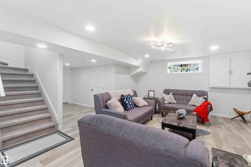 A spacious Rec Rm area featuring light-toned flooring, recessed lighting, and a modern light fixture - #1 Colonial Close, Beaumont, AB - Indoor Photo Showing Other Room