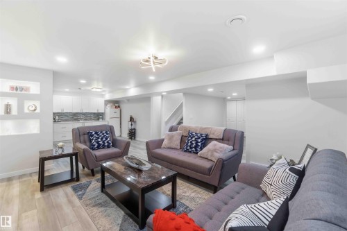 This open-concept Rec Rm features light-colored walls, recessed lighting, and light wood-style flooring - #1 Colonial Close, Beaumont, AB - Indoor Photo Showing Living Room