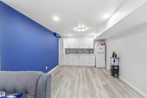 The property features light wood flooring, white cabinetry with a light-colored backsplash, and recessed lighting - #1 Colonial Close, Beaumont, AB - Indoor