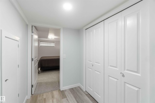 Hallway featuring light wood-style flooring and white bi-fold closet doors - #1 Colonial Close, Beaumont, AB - Indoor Photo Showing Other Room