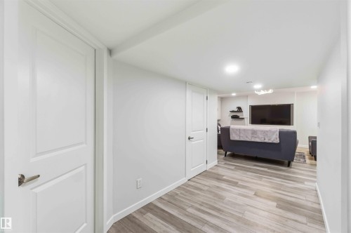 The property features a room with light-toned walls and wood-look flooring - #1 Colonial Close, Beaumont, AB - Indoor