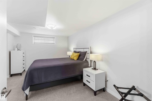 The property features a bright room with a window providing natural light, a neutral-toned carpet, and a ceiling light fixture - #1 Colonial Close, Beaumont, AB - Indoor Photo Showing Bedroom