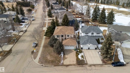 A view of the property from above, showcasing its corner lot location, attached garage, and mature landscaping - #1 Colonial Close, Beaumont, AB - Outdoor