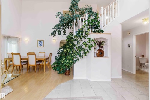 This property features an inviting entrance with tiled flooring, leading to a dining area with light-toned hardwood flooring - #1 Colonial Close, Beaumont, AB - Indoor