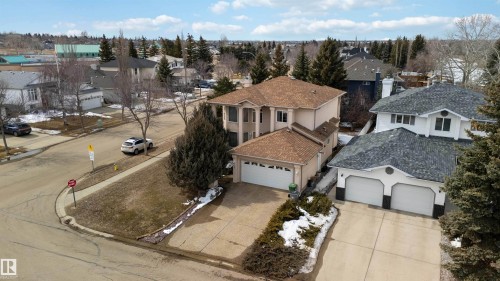 The property features a two-story design with a light-colored exterior and a brown shingled roof - #1 Colonial Close, Beaumont, AB - Outdoor