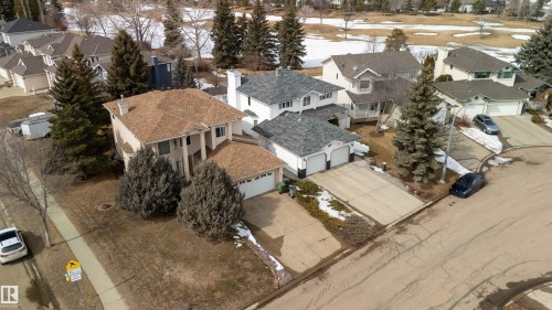 This property features a multi-level design with a prominent front entrance, an attached double garage, and a well-maintained lawn with mature landscaping - #1 Colonial Close, Beaumont, AB - Outdoor
