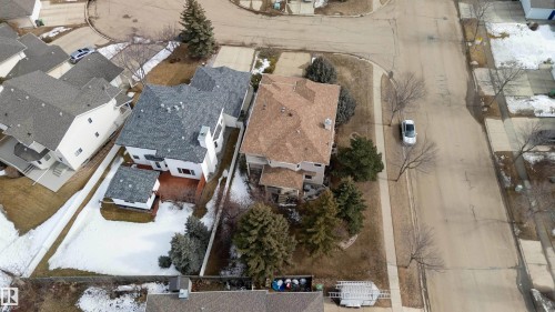 The property features a distinctive gray roof and a spacious rear deck, complementing its white exterior - #1 Colonial Close, Beaumont, AB - 