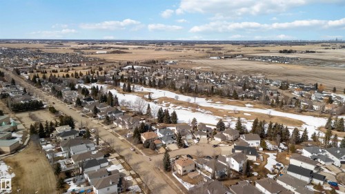 Aerial view displaying the surrounding community, residential streets with homes, and open land - #1 Colonial Close, Beaumont, AB - Outdoor With View