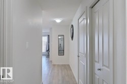 Hallway featuring wood-finish flooring, white paneled doors, and a flush-mount ceiling light - 