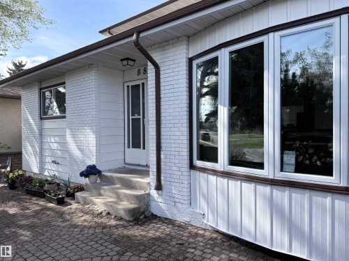 White brick and horizontal siding exterior with dark brown trim - 8812 135 Avenue, Edmonton, AB - Outdoor With Exterior