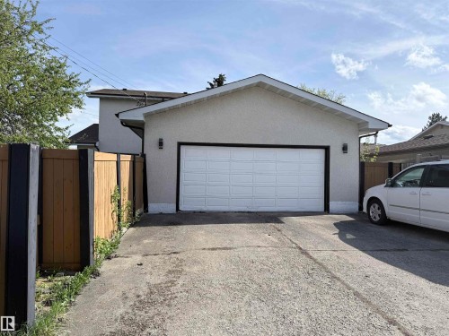 Attached garage featuring a white panel door with black trim - 8812 135 Avenue, Edmonton, AB - Outdoor With Exterior