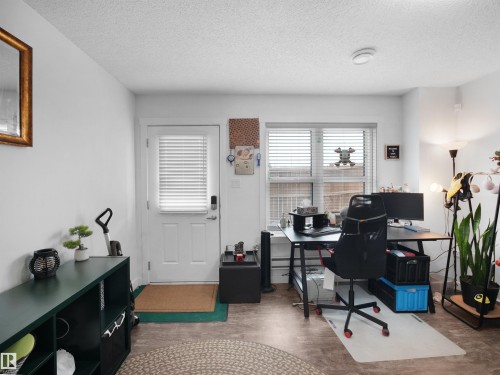 This versatile room features light-colored walls, a window with horizontal blinds, and a white door with a keyless entry system - 64 655 Watt Boulevard, Edmonton, AB - Indoor Photo Showing Office