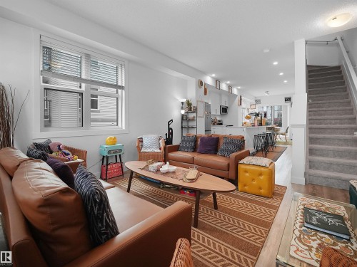 The open concept living area features light-colored walls and a window with blinds, providing natural light - 64 655 Watt Boulevard, Edmonton, AB - Indoor Photo Showing Living Room