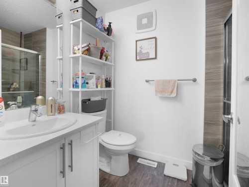 Bathroom featuring a white vanity with a rectangular sink, a toilet, and a shower with a glass enclosure - 64 655 Watt Boulevard, Edmonton, AB - Indoor Photo Showing Bathroom