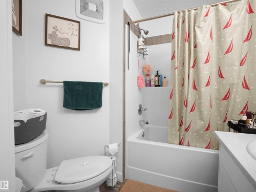 Bathroom featuring a white toilet, a bathtub with a shower, and a vanity with a sink - 64 655 Watt Boulevard, Edmonton, AB - Indoor Photo Showing Bathroom