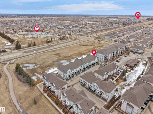 Aerial view showcasing the property's location within a developed community, featuring residential buildings and nearby infrastructure - 64 655 Watt Boulevard, Edmonton, AB - Outdoor With View