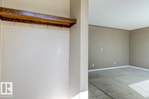 Entryway featuring a wood-finish shelf with hooks and a neutral-toned wall - 9602 90 Street, Edmonton, AB - Indoor Photo Showing Other Room