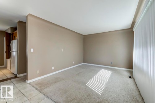 Spacious interior featuring neutral paint and light-colored carpeting - 9602 90 Street, Edmonton, AB - Indoor Photo Showing Other Room