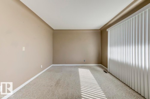 Spacious room featuring neutral-toned walls, white trim, and light-colored carpet flooring - 9602 90 Street, Edmonton, AB - Indoor Photo Showing Other Room