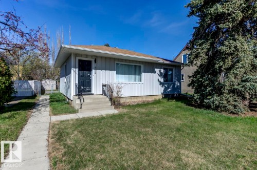 Single-story residence featuring light-colored vertical siding and a brown shingle roof - 9602 90 Street, Edmonton, AB - Outdoor