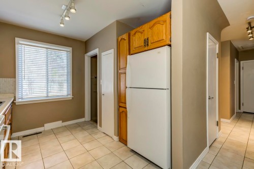 Kitchen area with ceramic tile flooring, wood cabinetry, and track lighting - 9602 90 Street, Edmonton, AB - Indoor Photo Showing Kitchen