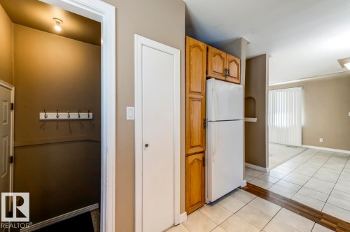 White refrigerator with wood-finish cabinetry - 9602 90 Street, Edmonton, AB - Indoor Photo Showing Kitchen