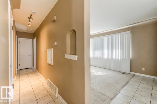 Hallway featuring ceramic tile flooring, recessed wall niche, and track lighting - 9602 90 Street, Edmonton, AB - Indoor Photo Showing Other Room