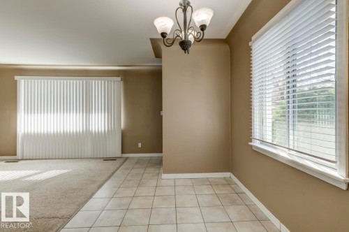 Dining area with tile flooring, a multi-bulb chandelier, and a window featuring white horizontal blinds - 9602 90 Street, Edmonton, AB - Indoor Photo Showing Other Room