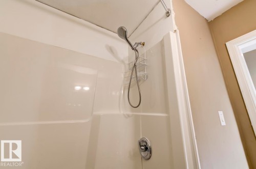 Shower enclosure featuring a handheld showerhead, chrome fixtures, and a neutral-toned wall finish - 9602 90 Street, Edmonton, AB - Indoor Photo Showing Bathroom