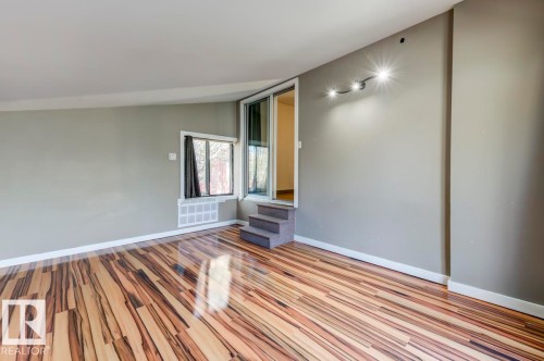 Light-filled room featuring wood-finish flooring, neutral wall paint, and white trim - 9602 90 Street, Edmonton, AB - Indoor Photo Showing Other Room
