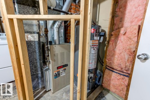 Utility area featuring a furnace, water heater, and exposed wood framing - 9602 90 Street, Edmonton, AB - Indoor Photo Showing Basement