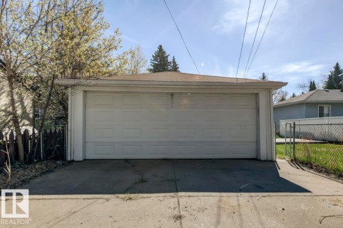 Two-car garage with white panel door and concrete driveway - 9602 90 Street, Edmonton, AB - Outdoor With Exterior
