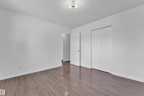 Spacious room featuring wood-finish flooring, white baseboards, and a neutral wall palette - 3520 19 Avenue, Edmonton, AB - Indoor Photo Showing Other Room