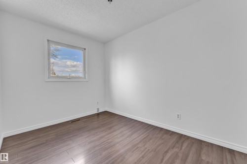 Room featuring a single-pane window, wood-finish flooring, white baseboards, and white walls - 3520 19 Avenue, Edmonton, AB - Indoor Photo Showing Other Room