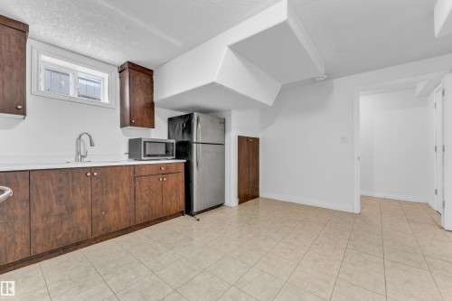Kitchenette featuring wood-finish cabinetry, white countertops, and a stainless steel sink with a gooseneck faucet - 3520 19 Avenue, Edmonton, AB - Indoor Photo Showing Kitchen