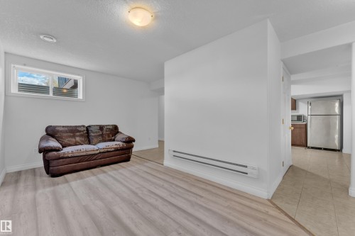 Bright interior space featuring light wood-finish flooring, white walls, and a ceiling-mounted light fixture - 3520 19 Avenue, Edmonton, AB - Indoor