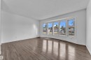 Bright interior space featuring a five-panel bay window, wood-finish flooring, and crisp white walls - 3520 19 Avenue, Edmonton, AB  - Indoor Photo Showing Other Room 