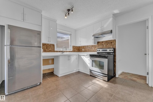 Kitchen featuring white cabinetry, brown tile backsplash, and ceramic floor tiling - 3520 19 Avenue, Edmonton, AB - Indoor Photo Showing Kitchen