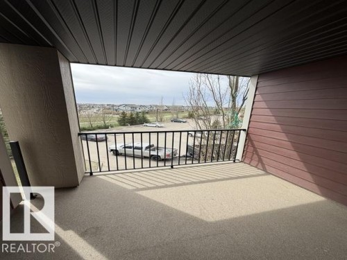 Private balcony featuring a textured floor, black metal railing, and a slatted ceiling - 321 107 Watt Common, Edmonton, AB - Outdoor With Exterior